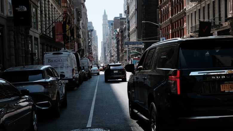 A closeup look from street level is shown at vehicles not in motion in a large city.