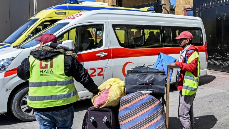 Workers wearing bright yellow vests that say 