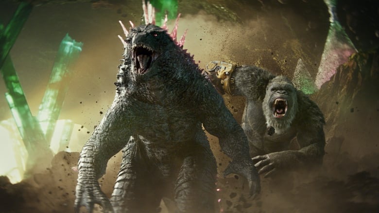 A giant lizard, left and a giant gorilla roar as they run through a cave full of large crystals. 