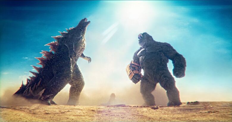 A giant lizard and giant ape stand next to one another. Both are roaring. 