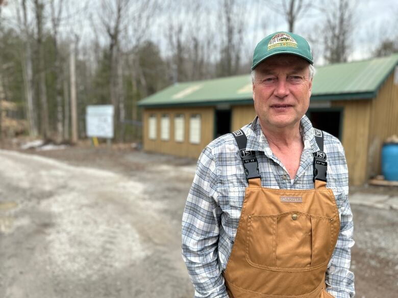 A sugar shack worker outside of one of his buildings.