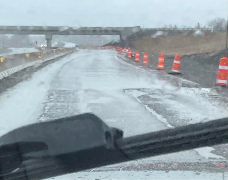 Potholes on a pylon-lined higway on a rainy day.