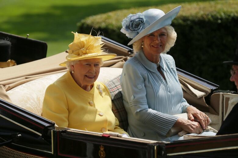 Two people ride in an open carriage.