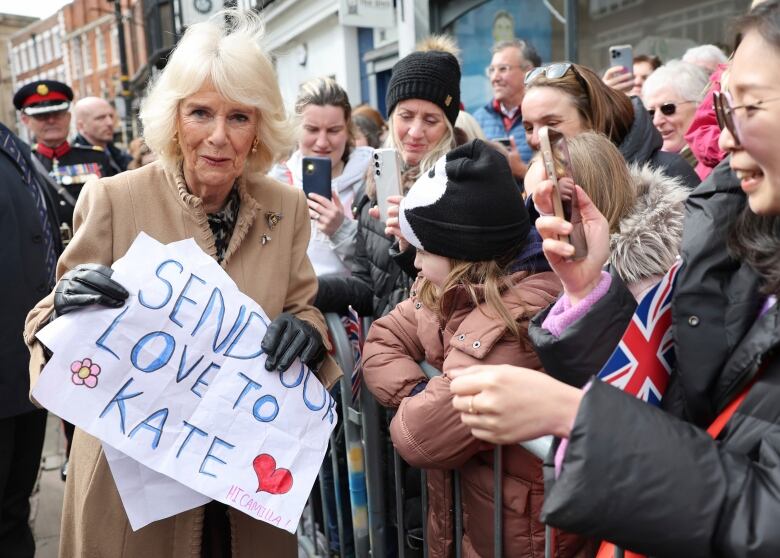 A person holds a sign reading 