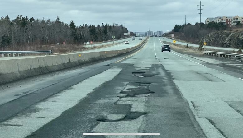 Potholes along a stretch of highway in Nova Scotia on a cloudy day.