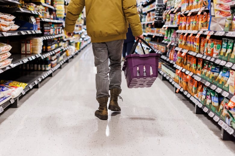 A man walks down a grocery store aisle