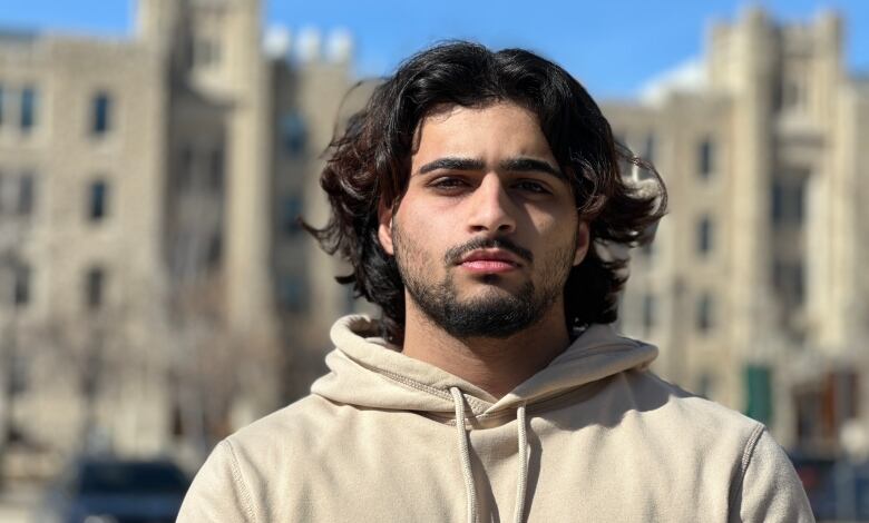 A man with long hair and beard, wearing a hoodie.