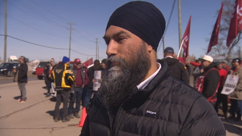 A man with a crowd of protesters behind him.