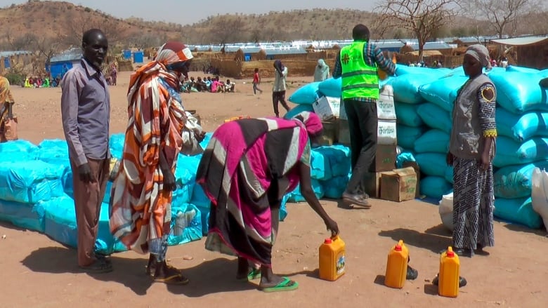 A group of refugess gather to recieve food from aid workers.