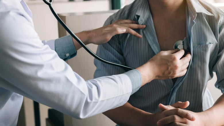 A doctor puts a stethoscope on a person.