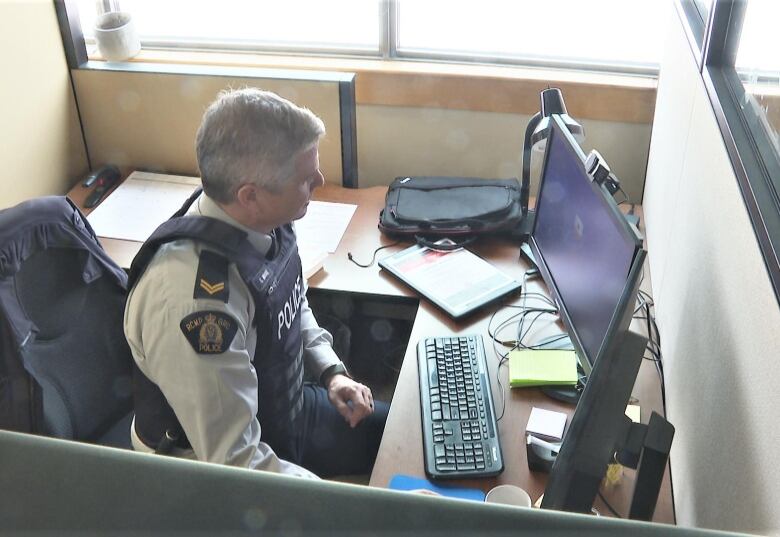 Gavin Moore sits and looks at a computer screen.