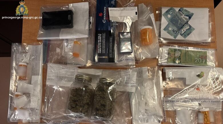 A police seizure showing money and drugs on a table.