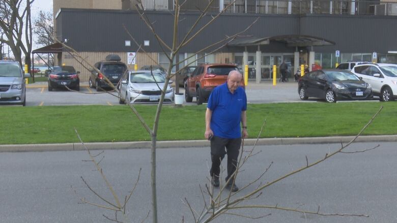 A senior-age man crosses a quiet city street.