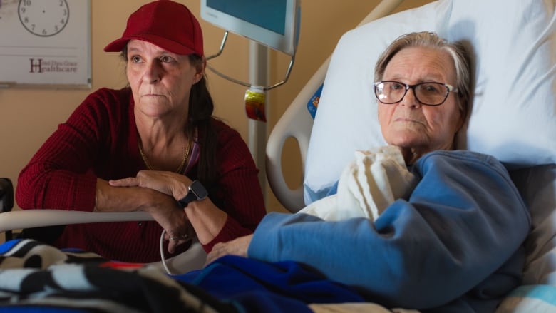 Michele Campeau, left, visits with her mother, Ruth Poupard, 83, at Hotel-Dieu Grace Healthcare where she is recovering from a broken hip, in Windsor, Ont., on Wednesday, April 3, 2024. Poupard also suffers from dementia and requires 24-hour care. 