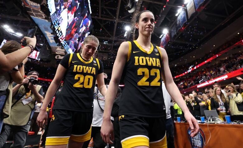 Two basketball players walk off the court.