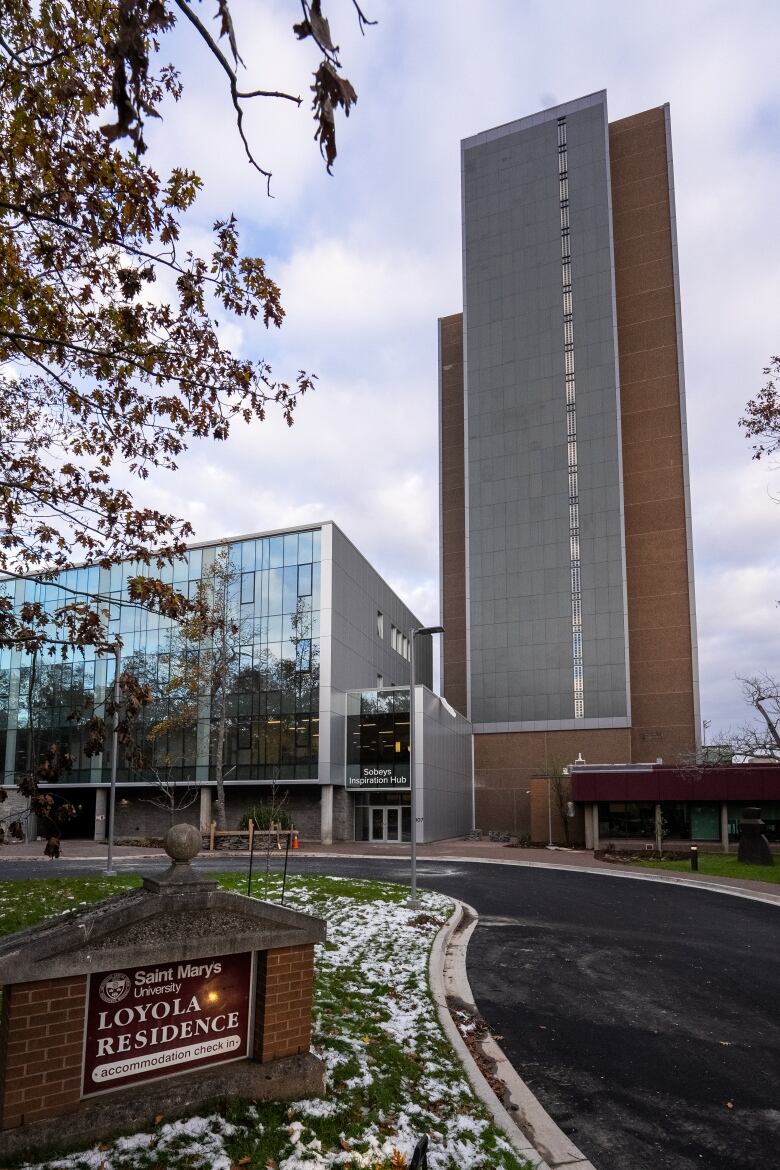 A tall tower with a big grey panel over the front side and a sign in front that says 