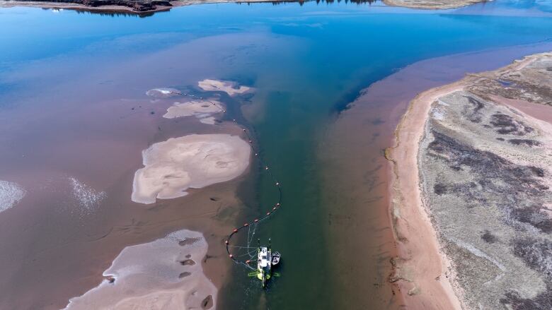 An overhead view of a dredge in a shallow section of water 