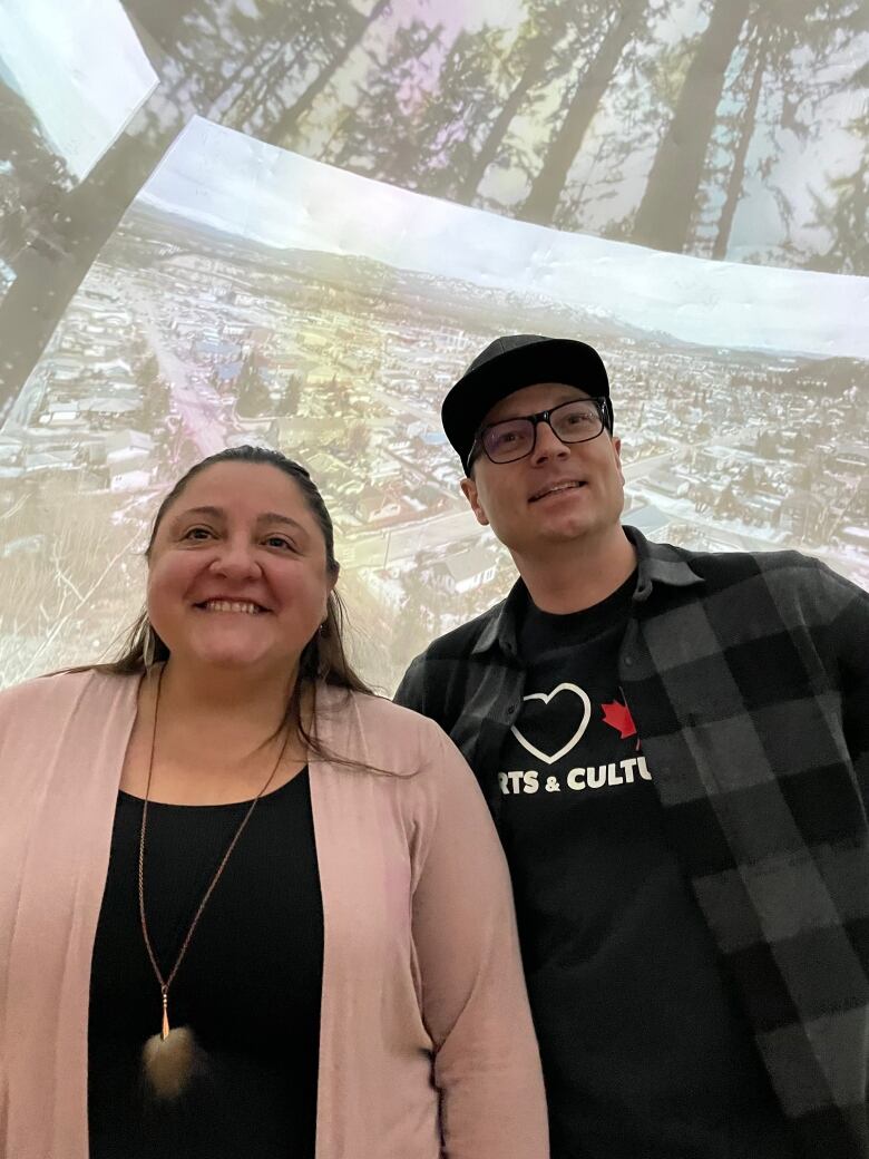 Two people standing in front of art project