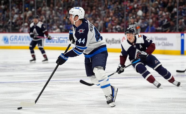 Hockey players skate on the ice.