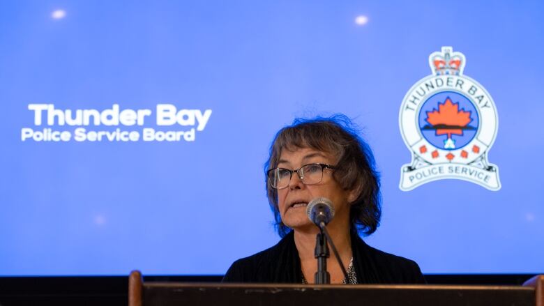 A woman speaks at a podium during a press conference. 