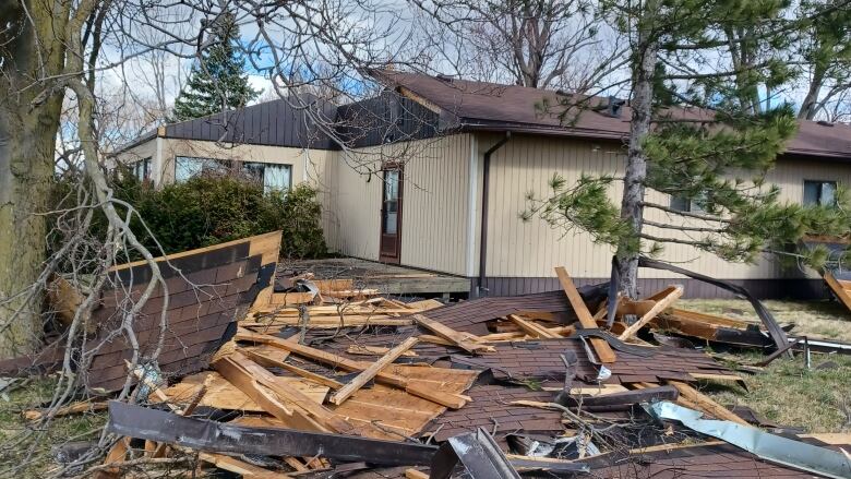 Roof shingles and other debris in front of a building.