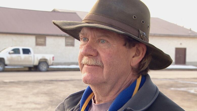 A man wearing a cowboy hat smiles for the camera