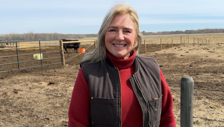 Brenda Otto is pictured in front of a field with cattle in the background. 