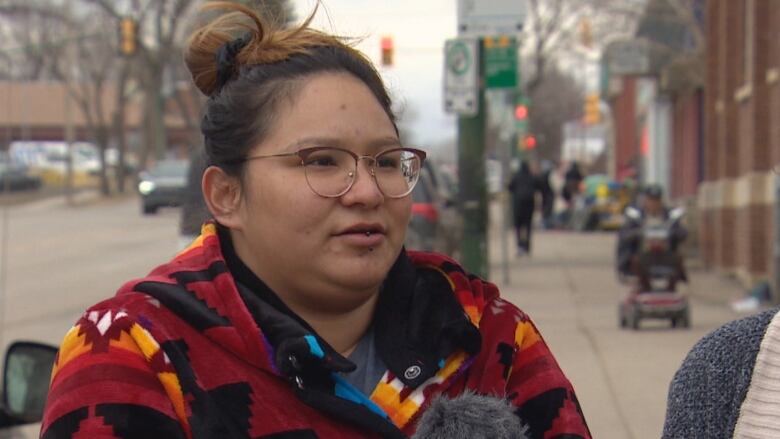 Shayla Shingoose pictured in a red hoodie wearing glasses. 