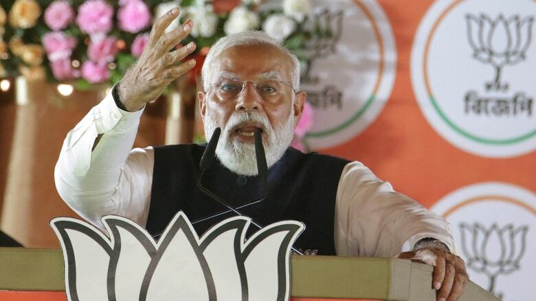 Narendra Modi speaks at a microphone.