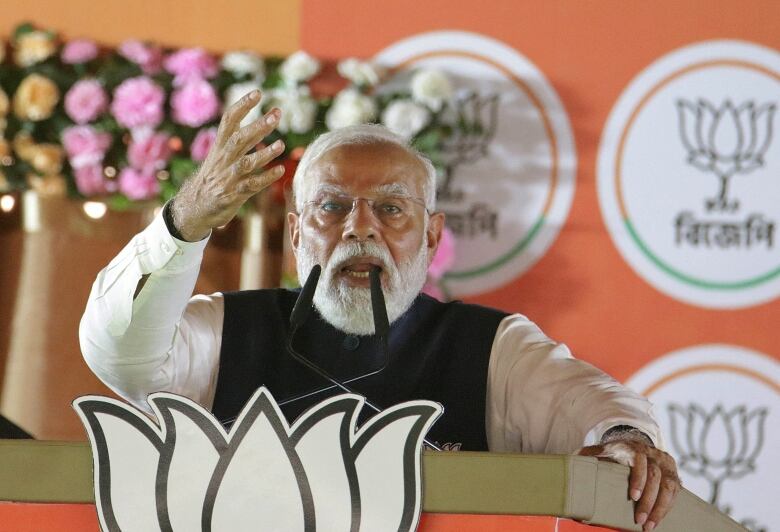 Narendra Modi speaks at a microphone.