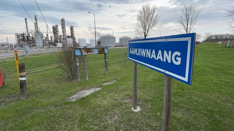 Aamjiwnaang sign is seen here with a large industrial plant in the background.