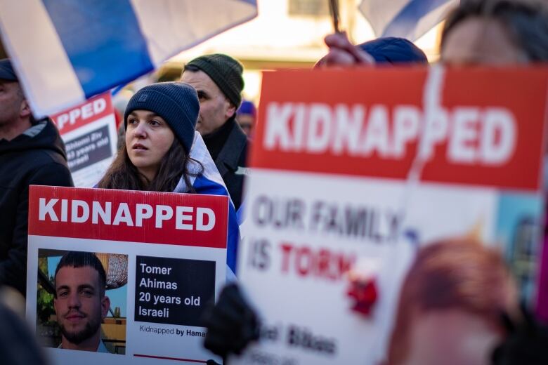 People hold signs during a rally for Israel and the release Hamas hostages, in Vancouver on Sunday, Jan. 14, 2024.