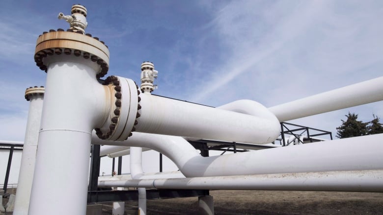 A complex arrangement of large, white pipes are seen against a blue sky.