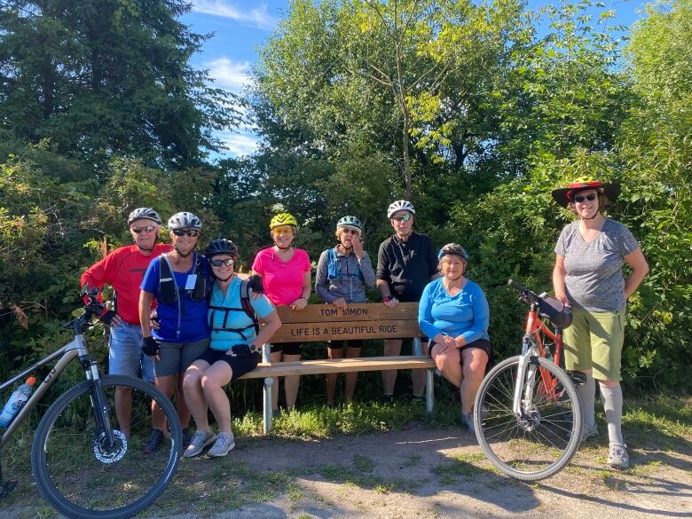 Members of the Halton Outdoors Club, which Tom Simon was a member of pose in front of his commemorative bench.