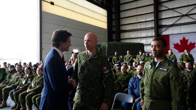 Prime Minister Justin Trudeau shakes hands with Chief of Defence Staff Gen. Wayne Eyre following a press conference about Canada's new defence policy at CFB Trenton, in Trenton, Ont., on Monday, April 8, 2024.