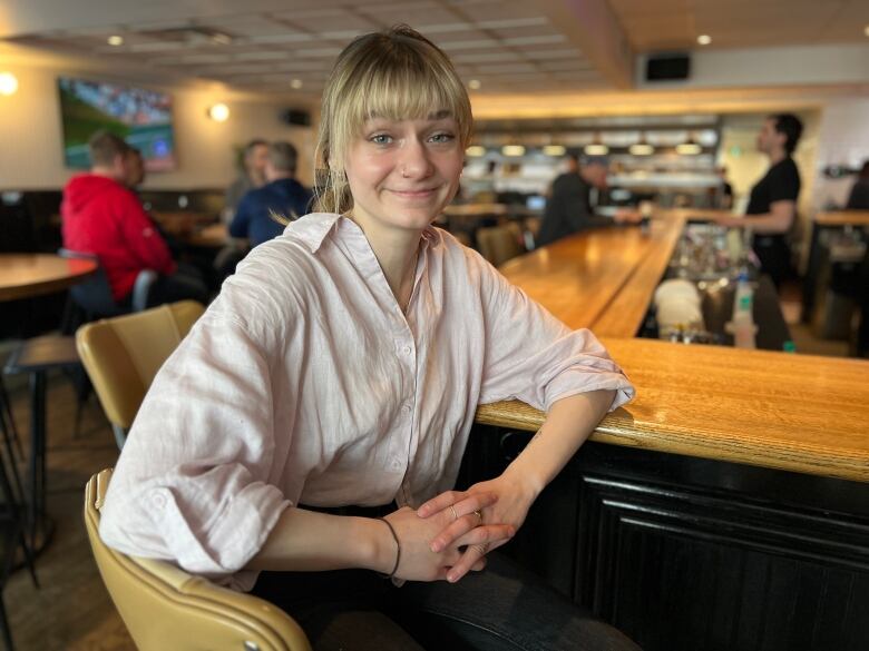 A woman sits at a bar. 