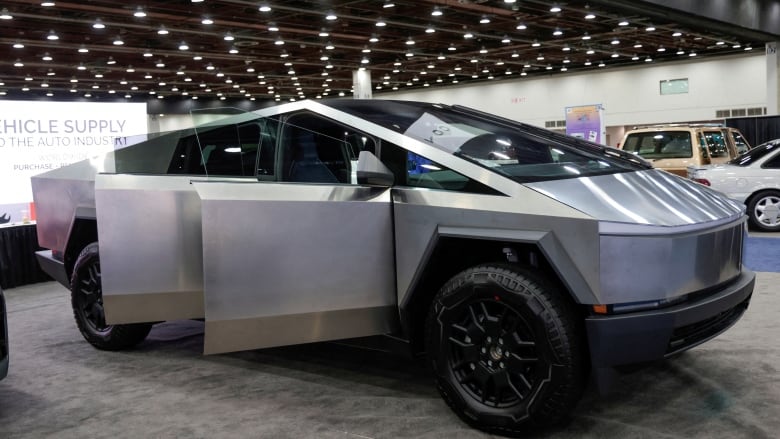 A silver Tesla Cybertruck at a trade show.