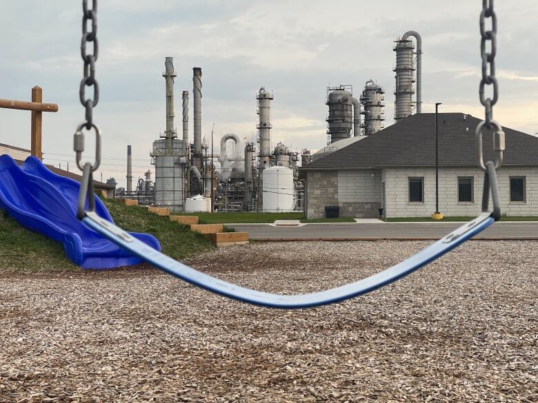 Swing in the foreground and a chemical plant in the background