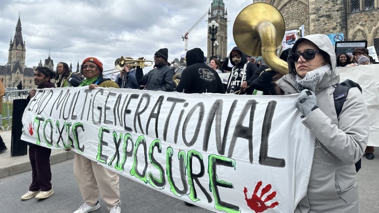 A sign held by demonstrators reads 