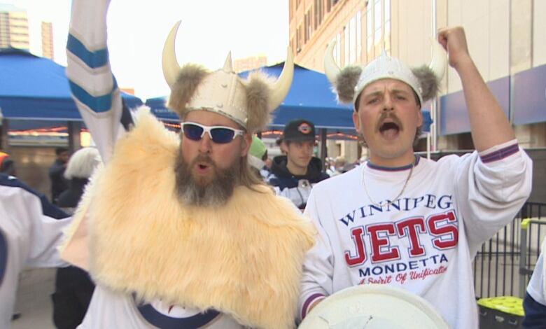 Two people wearing viking helmets