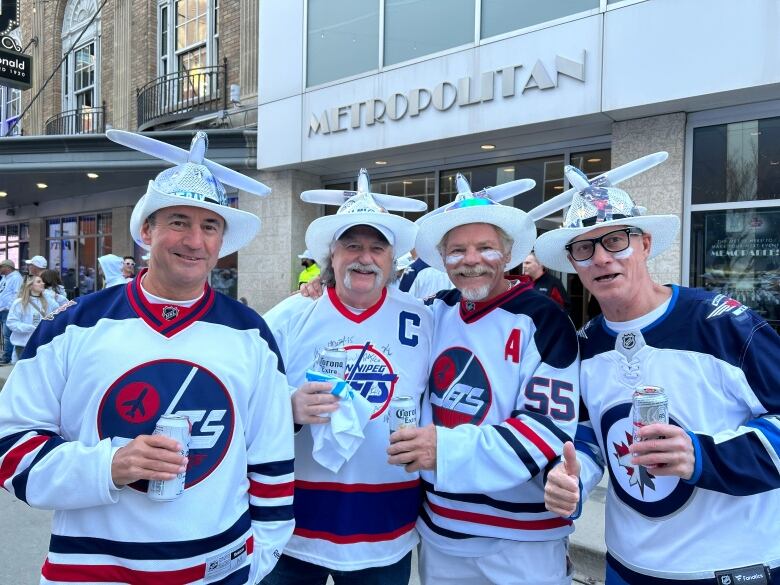 People wearing Jets jerseys and hats with airplanes on top of them