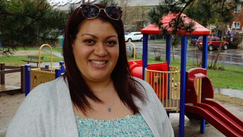 A mother near a playground on a rainy spring day.