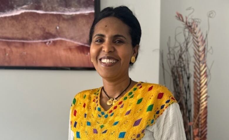 A woman dressed in a traditional Eritrean dress is pictured.