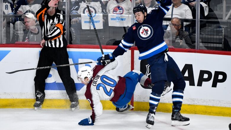 Two hockey players collide along the boards.