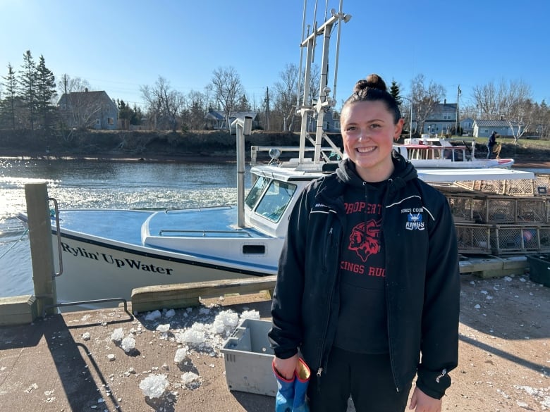 Woman standing in front of fishing boat.