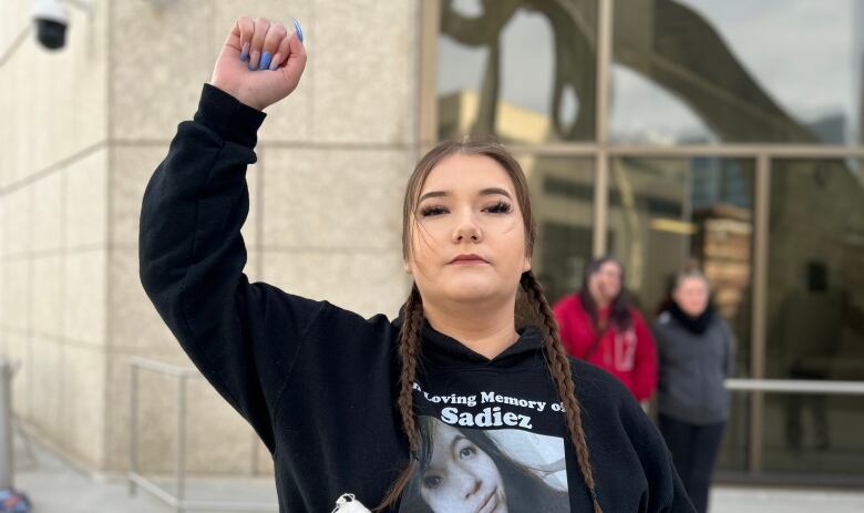 A woman raising her right fist.