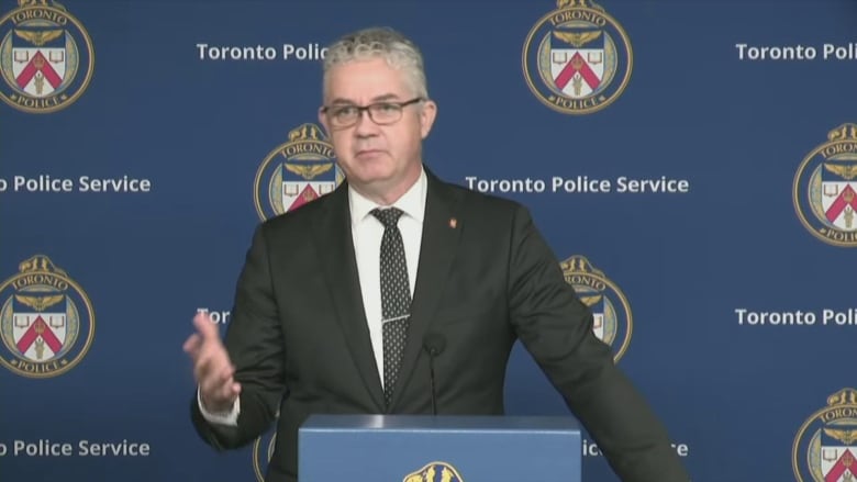 A man stands behind a podium at a Toronto Police Service news conference.