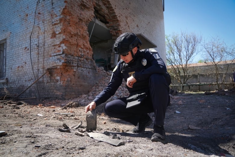 A police officer examines fragments of a guided bomb that was launched at Kharkiv.