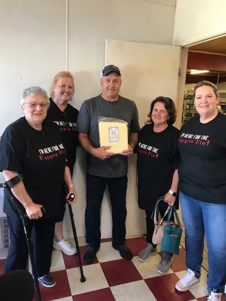 Four women wearing black shirts that say, 