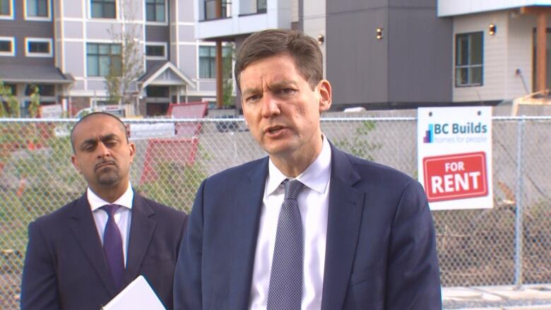 Two men in suits outdoors.